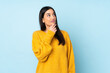 © luismolinero - Young caucasian woman isolated on blue background having doubts