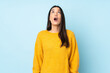 © luismolinero - Young caucasian woman isolated on blue background looking up and with surprised expression