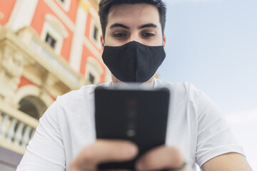 Wall Mural - Spanish man in a mask playing with his phone