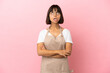 © luismolinero - Restaurant waiter over isolated pink background looking up and with surprised expression