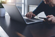 © tippapatt - Casual business man freelancer surfing the internet on laptop computer and using mobile phone at home office