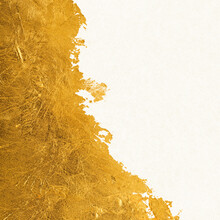 Shiny Textured Gold Leaf Foil Torn Across White Paper.