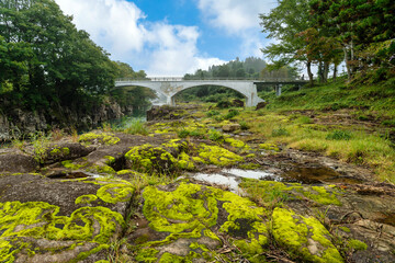 Wall Mural - A rock with green moss and waterlogging The foggy morning countryside gives a refreshing atmosphere at Geibikei, a ravine in the Satetsu River in Ichinoseki City, Iwate Prefecture, Japan,