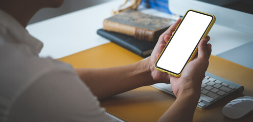 Close up view of businessman holding mock up smart phone with blank screen.