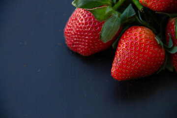 healthy food ripe berries of red garden strawberries on a dark background