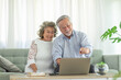 © 220 Selfmade studio - Happy Wellness Asian Elderly or Seniors couple with white hairs using computer laptop VDO Conference Call online meeting with family and smile at home,Retirement lifestyle at home concept