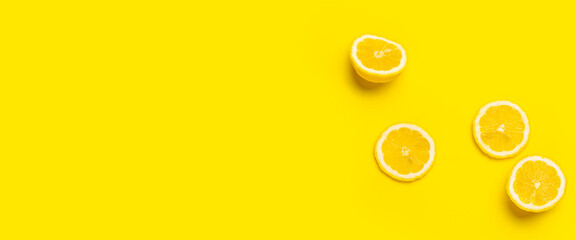 Canvas Print - lemon wedges and sliced lemon on a yellow background. Top view, flat lay. Banner