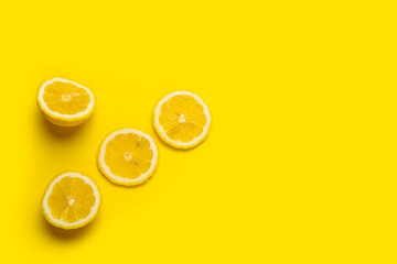 Canvas Print - lemon wedges and sliced lemon on a yellow background. Top view, flat lay