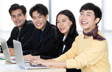 Wall Mural - A group of multi-sex colleagues businesspeople, tomboy and transgender gay, working together with happy and intimate manner with laptop notebook computer in office