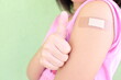 © sulit.photos - Closeup of shoulder of a vaccinated young Asian girl with adhesive bandage in thumbs up. Young people, children and kids vaccination for covid-19 vaccine.