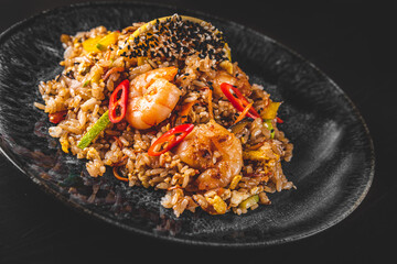 Wall Mural - Fried rice with shrimp and vegetables in plate on wooden table background