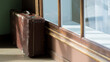 Vintage shabby suitcase stands by the window