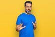 © Krakenimages.com - Middle aged man with beard wearing casual blue t shirt disgusted expression, displeased and fearful doing disgust face because aversion reaction. with hands raised