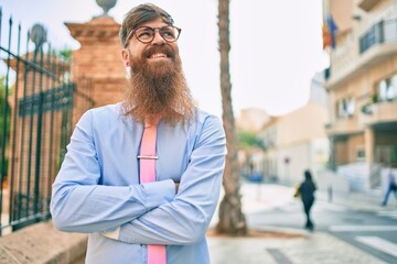 Sticker - Young redhead businessman with crossed arms smiling happy  at the city.