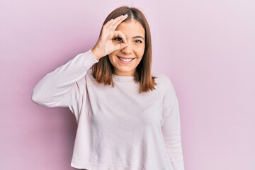 Canvas Print - Young beautiful woman wearing casual clothes smiling happy doing ok sign with hand on eye looking through fingers