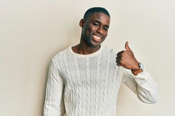 Young african american man wearing casual clothes doing happy thumbs up gesture with hand. approving expression looking at the camera showing success.