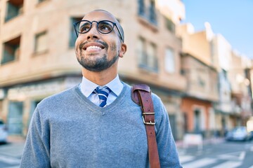 Poster - Young african american businessman smiling happy walking at the city.