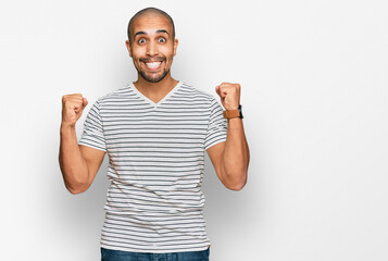 Poster - Hispanic adult man wearing casual clothes celebrating surprised and amazed for success with arms raised and open eyes. winner concept.