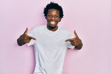 Sticker - Young african american man wearing casual white t shirt looking confident with smile on face, pointing oneself with fingers proud and happy.