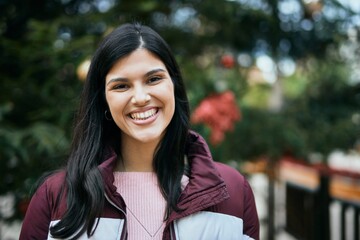 Young hispanic girl smiling happy standing at the park.