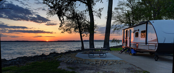 travel trailer camping at sunset by the mississippi river in illinois at sunset panorama