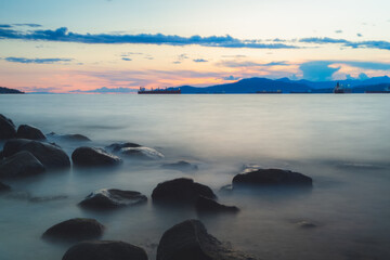 Wall Mural - Sunset or sunrise seascape from rocky shore at Kitsilano Beach on an idyllic summer evening in Vancouver, B.C., Canada.