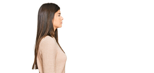 Poster - Young brunette woman wearing casual winter sweater looking to side, relax profile pose with natural face and confident smile.