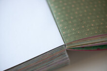 Pink And Green Dots On Earthy Green Scrapbooking Paper Bound Together - Photographed With A Macro Lens With Particular Focus On The Folded Sheets