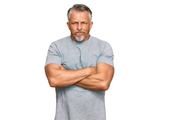 Wall Mural - Middle age grey-haired man wearing casual clothes skeptic and nervous, disapproving expression on face with crossed arms. negative person.