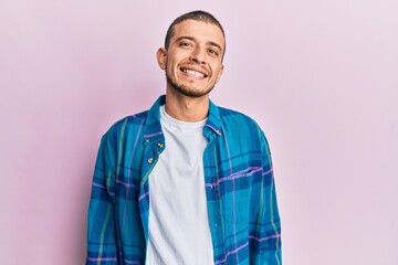 Hispanic young man wearing casual clothes looking positive and happy standing and smiling with a confident smile showing teeth