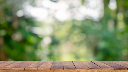 Natural wooden table background with blurred green natural background for displaying merchandise or designing important photo layouts.