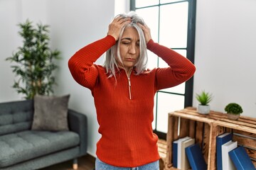 Canvas Print - middle age grey-haired woman wearing casual clothes standing at home suffering from headache despera