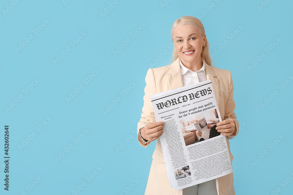 Mature woman with newspaper on color background