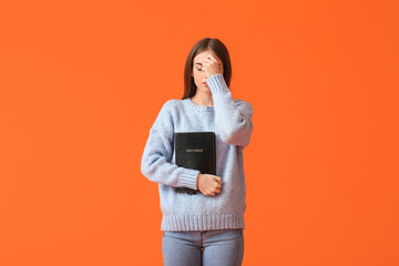 Wall Mural - Young woman with Bible on color background