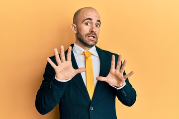 Sticker - Young hispanic man wearing business suit and tie afraid and terrified with fear expression stop gesture with hands, shouting in shock. panic concept.