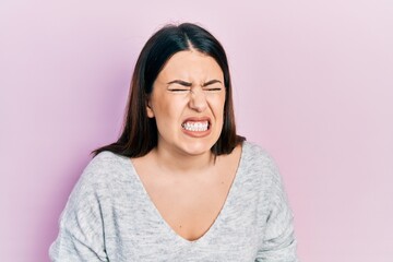 Poster - Young hispanic woman wearing casual clothes with hand on stomach because nausea, painful disease feeling unwell. ache concept.