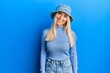 Young blonde woman wearing casual denim hat with a happy and cool smile on face. lucky person.