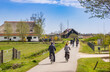 People riding their bicycle in the landscape of Friesland, Netherlands