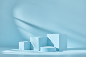 Wall Mural - Blue background for product presentation with shadows and light. Empty podiums. Mockup.