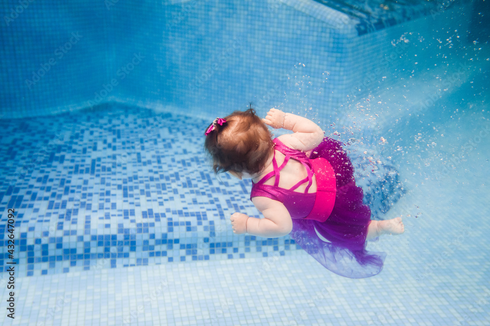Little baby, girl swimming under water in paddling pool. Diving baby ...