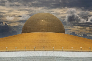 Wall Mural - Million golden Buddha figurine in Wat Phra Dhammakaya against a dramatic sky. Buddhist temple in Bangkok, Thailand