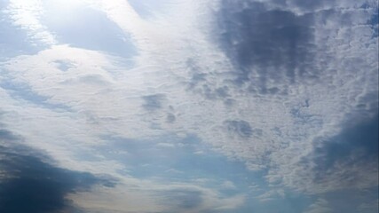 Wall Mural - clouds flying across a blue sky with a bright sun. time lapse of cumulus cloud, summer sunny day. na