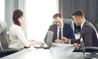 © Maksim Selin - Group of young successful businessmen lawyers communicating together in a conference room while working on a project