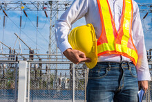Electrician Holding A Helmet Yellow Hat With Power Station Background