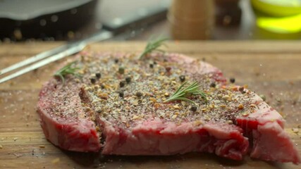 Sticker - dropping and seasoning rib eye beef steak on wooden cutting board