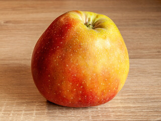 Ripe red and yellow apple on a wooden mat