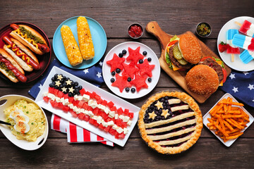 Fourth of July, patriotic, American themed food. Above view table scene on a dark wood background.