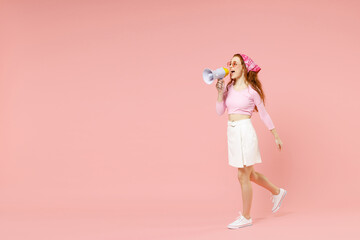 Poster - Full length young expressive excited caucasian woman wear rose clothes bandana glasses scream shout hot news in megaphone isolated on pastel pink background studio portrait. People lifestyle concept.