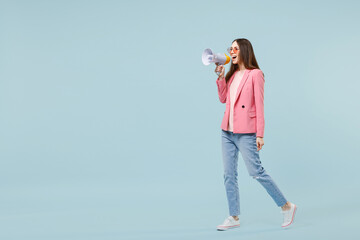 Full length side view young fun happy caucasian woman in pastel pink clothes glasses scream shouting hot news aside in megaphone isolated on blue background studio People lifestyle technology concept