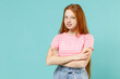 Little smiling confident redhead kid girl 12-13 years old wearing pink striped tshirt hold hand crossed folded isolated on pastel blue background studio portrait. Children lifestyle childhood concept